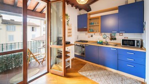 A modern kitchen with blue cabinets, a microwave, and a stove.