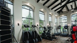 A gym with treadmills, elliptical machines, and weight equipment.