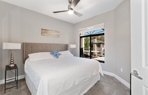 A bedroom with a bed, two bedside tables, a ceiling fan, a window with a view, and a door. - Pure Suites Scottsdale Kierland Commons Scottsdale Quarter 2 Bed Pool Gym (Scottsdale)