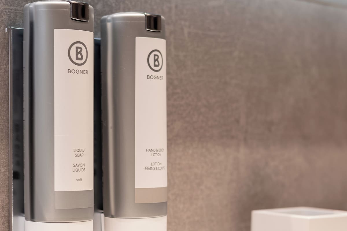 Two bottles of liquid soap and lotion with the brand name 'BOGNER' on a bathroom counter.