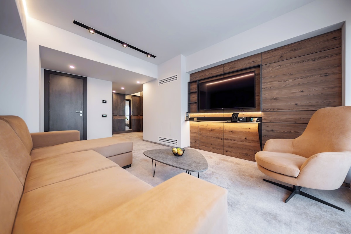 A modern living room with a sofa, armchair, and coffee table.