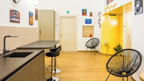 A modern interior with a kitchen area, seating, and a mural. - Guest Rooms Bellini - Totò - Studios Superior (Naples)