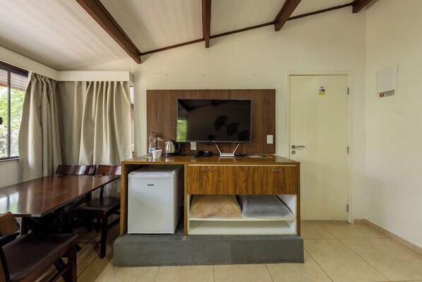 A compact kitchen with a refrigerator, wooden cabinets, a built-in microwave, and a sink. - Hotel Fazenda da APM by Bhomy (Caieiras)
