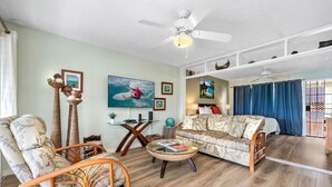 A living room with a sofa, chairs, a coffee table, and a ceiling fan. - Cozy Ocean View 1-bedroom, 1 bath condo in awesome Kailua-Kona with AC (Kailua-Kona)