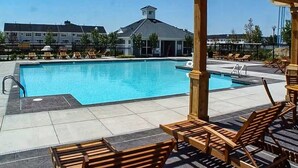 A swimming pool with lounge chairs and a covered seating area. - Welcome to a Cozy Waterfront Condo in Charming Cambridge, MD (Cambridge)