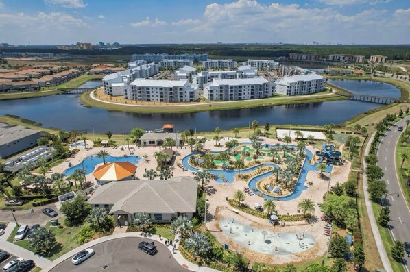 A modern hotel complex with multiple buildings, a central courtyard with a swimming pool, and a water park.