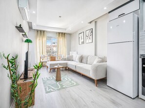 A modern living room with a sofa, coffee table, and a flat-screen TV.