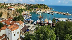 Un pueblo costero con un puerto deportivo, edificios históricos y una imponente fortificación.