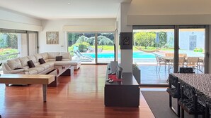 A modern living room with a sofa, coffee table, and dining area.