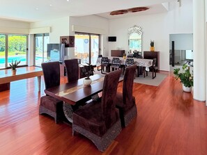 A spacious dining area with a long table, multiple chairs, and a view of the outdoors.