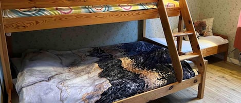 A bunk bed with a wooden frame and a colorful blanket.