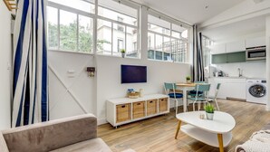 Un apartamento moderno con ventanas amplias, cocina, comedor y sala de estar.