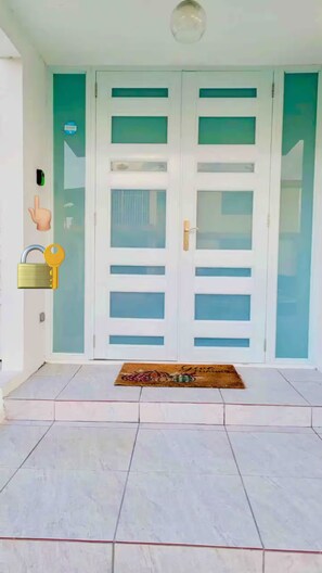 A white door with frosted glass panels and a keyhole lock. - Casa Dos Palmas-House with Solar System and just 8 Min from the Airport. (San Juan)