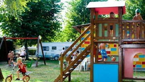 A playground with a wooden play structure, including a slide and a climbing area. - Butterfly Vacation Park: Happy Superior Mobile Home for 7 People (Peschiera del Garda)