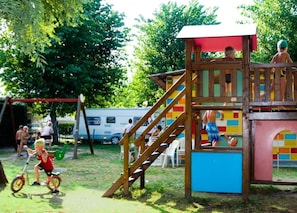 A playground with a wooden play structure, including a slide and a climbing area.