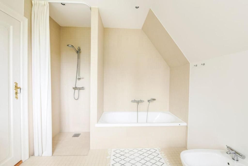 A modern bathroom with a shower, a bathtub, and a sink.