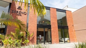 A hotel named SERENO with a modern brick facade, large glass windows, and a visible entrance. - Sereno Hotel (Cabo Frio)