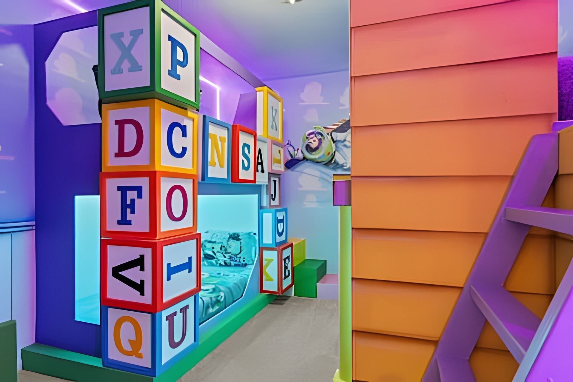 A children's play area with alphabet blocks and a bed.