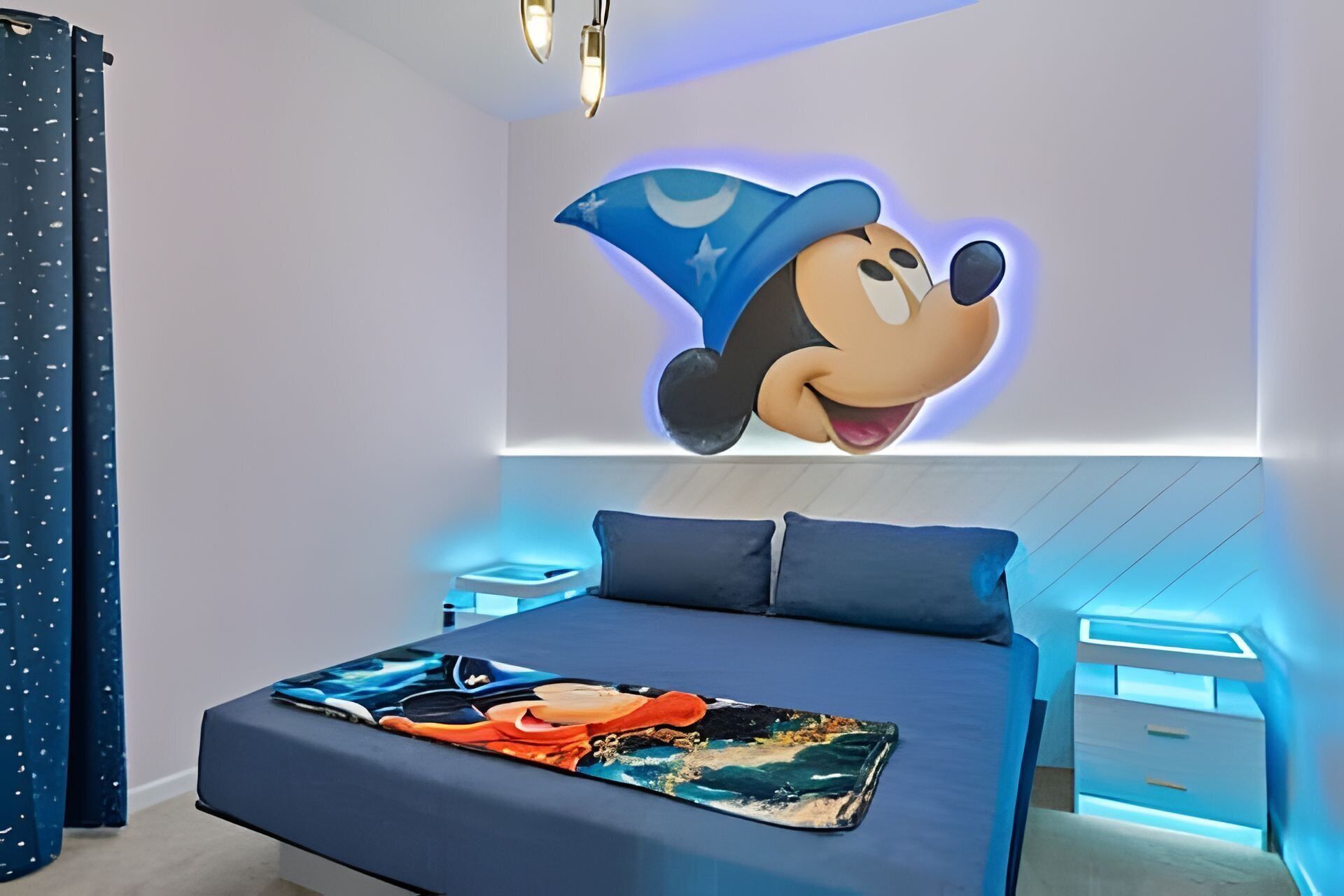 Une chambre avec un grand lit, une fresque murale représentant Mickey Mouse et un motif de ciel étoilé au plafond.
