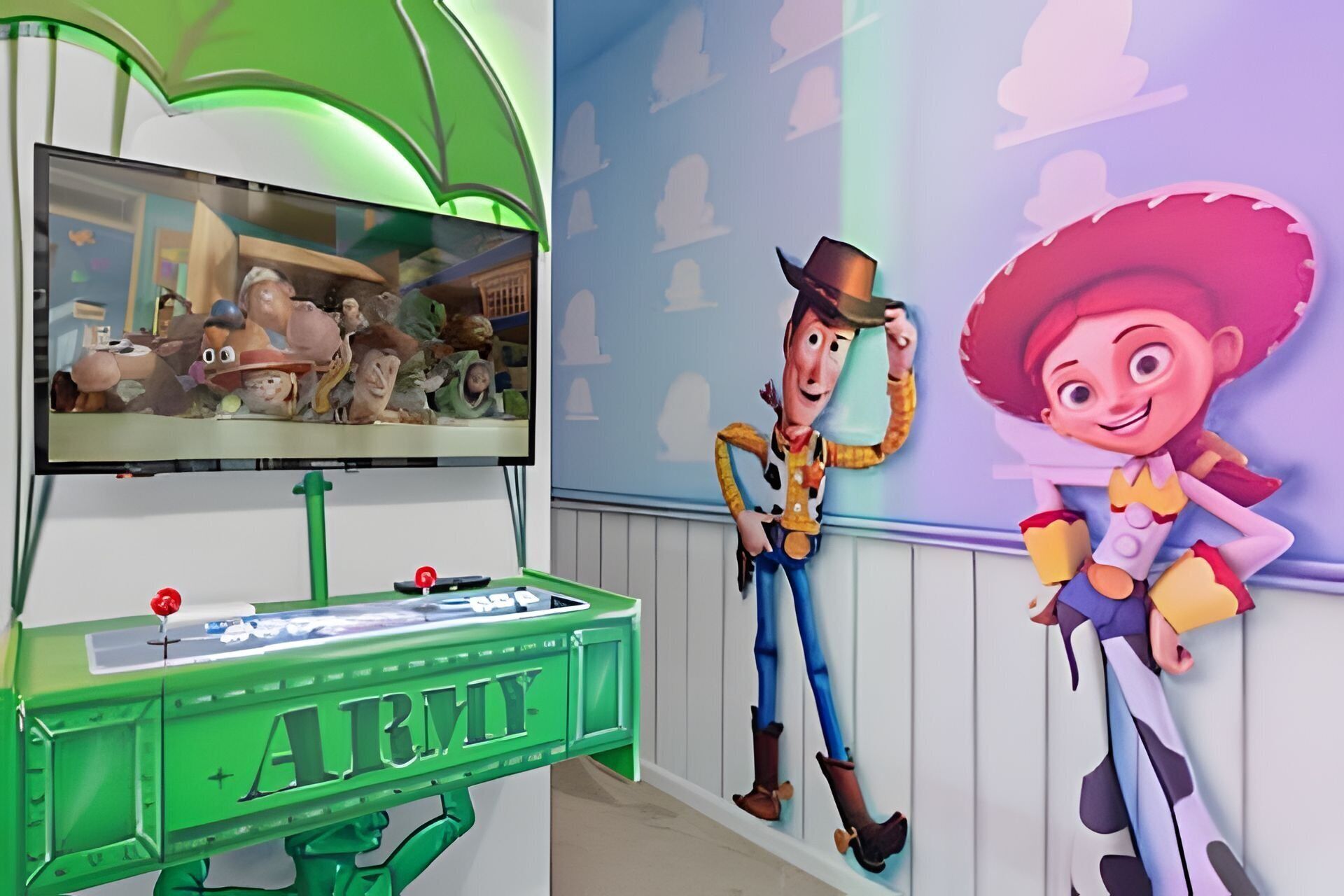 Een kamer met een televisie waarop een filmscène te zien is, een groen kastje met de tekst 'ARMY' en twee grote uitgesneden afbeeldingen van tekenfilmfiguren.
