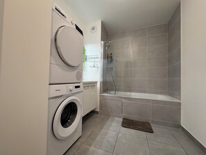 Een haardroger, handdoeken, zeep, toiletpapier