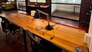 A wooden desk with a lamp, a chair, and a view of greenery outside. - Agapi (Cahuita)