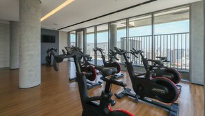 A gym with cardio machines, large windows, and a city view. - Flat Moderno Perto do Metr e do Parque Ibirapuera (São Paulo)