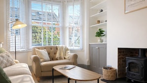 Ein gemütliches Wohnzimmer mit einem beigen Sofa, einem Holztisch und einem Kamin.