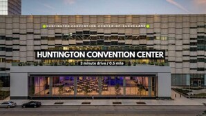 L’extérieur du Huntington Convention Center présente un design moderne, avec une grande façade en verre et un panneau indiquant qu’il se trouve à 3 minutes en voiture du centre-ville de Cleveland.