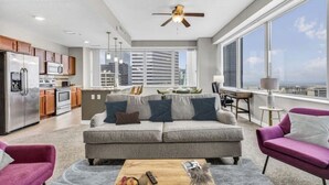 Um apartamento moderno com cozinha, sala de estar e grandes janelas com vista para a cidade.
