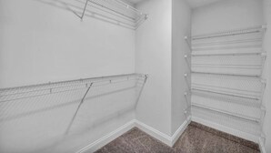 A corner closet with wire shelving units and a carpeted floor. - Central Downtown Loft FREE Parking•Gym•Security (Cleveland)