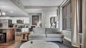 A modern kitchen with white cabinets, stainless steel appliances, and a central island. - Elegant 2BD Condo in the Heart of Downtown • Gym (Cleveland)
