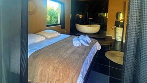 A modern bathroom with a large bathtub, a sink, and a mirror.
