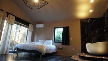 A modern bedroom with a bed, a large window with curtains, a black marble wall, and a unique light fixture.