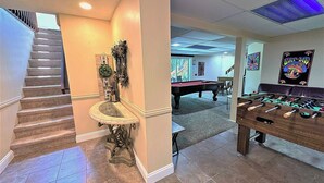 A room with a pool table, foosball table, and a staircase. - WOW!! Poconos Retreat, Hot Tub, Game Room, Deck, Lakes, Skiing, Pools, Firepit (Long Pond)