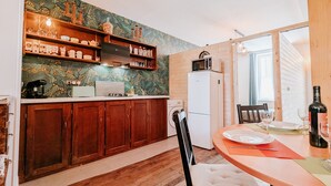 A compact kitchen with wooden cabinets, a microwave, and a refrigerator. - Spacious cottage near Éguzon Lake (Orsennes)