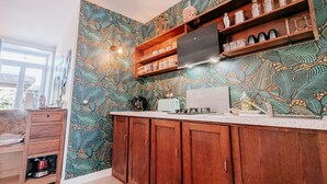 A kitchen with wooden cabinets, a countertop, and a backsplash with a leaf pattern. - Spacious cottage near Éguzon Lake (Orsennes)
