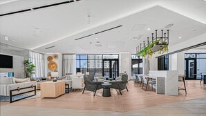 Amplia sala de estar con diseño moderno, que incluye una zona de estar, una mesa de centro y un área de cocina con encimera de mármol.