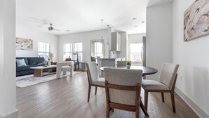 Ein modernes Wohnzimmer mit einer Couch, einem Couchtisch und einem Essbereich mit Stühlen und einem Tisch.