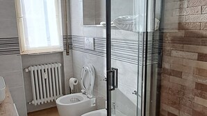 A modern bathroom with a glass shower enclosure, a toilet, a bidet, and a bathtub. - Minimal suite - Novarese night (Novara)