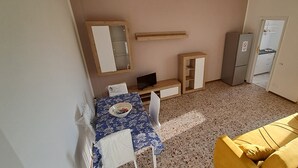 A compact living space with a kitchenette, a dining area with a table and chairs, and a sofa. - Minimal suite - Novarese night (Novara)