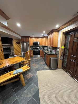 A kitchen with wooden cabinets, a stainless steel refrigerator, a microwave, and a stove.