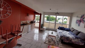 A modern apartment with a kitchen, dining area, and living room. It features a large window, a sofa, and a coffee table. - Studio ideally located (Sens)