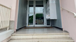 A building entrance with a set of stairs leading up to a door. - Studio ideally located (Sens)