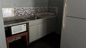 A kitchen with a microwave, sink, and refrigerator.