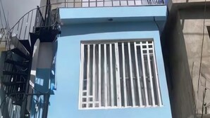 A multi-story building with a blue facade, a barred window, and a metal staircase. - LA CASITA DE CHEPE - Iconic apartment in Gaspar Hernandez (Gaspar Hernández)