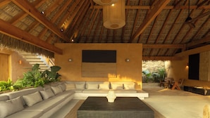 A modern living room with a sectional sofa, a coffee table, and a large painting on the wall.