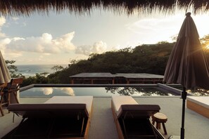 A poolside area with lounge chairs and a wooden deck overlooking the ocean. - Casa Yute Boutique Hotel Playa Aragon (Santa María Tonameca)