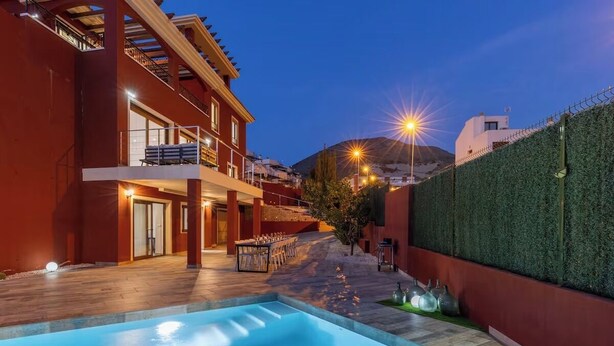 A modern building with a swimming pool, outdoor seating, and a view of a mountain. - -Nuevo Anuncio- Bádminton Villa & Sea Views (Finestrat)