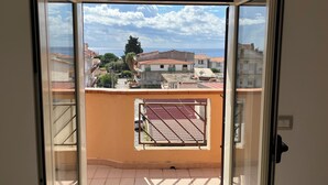A balcony with a view of a residential area, including houses and a tree. - Kalon Eidos. The magical place of Ionian Calabria (San Carlo-Condofuri Marina)